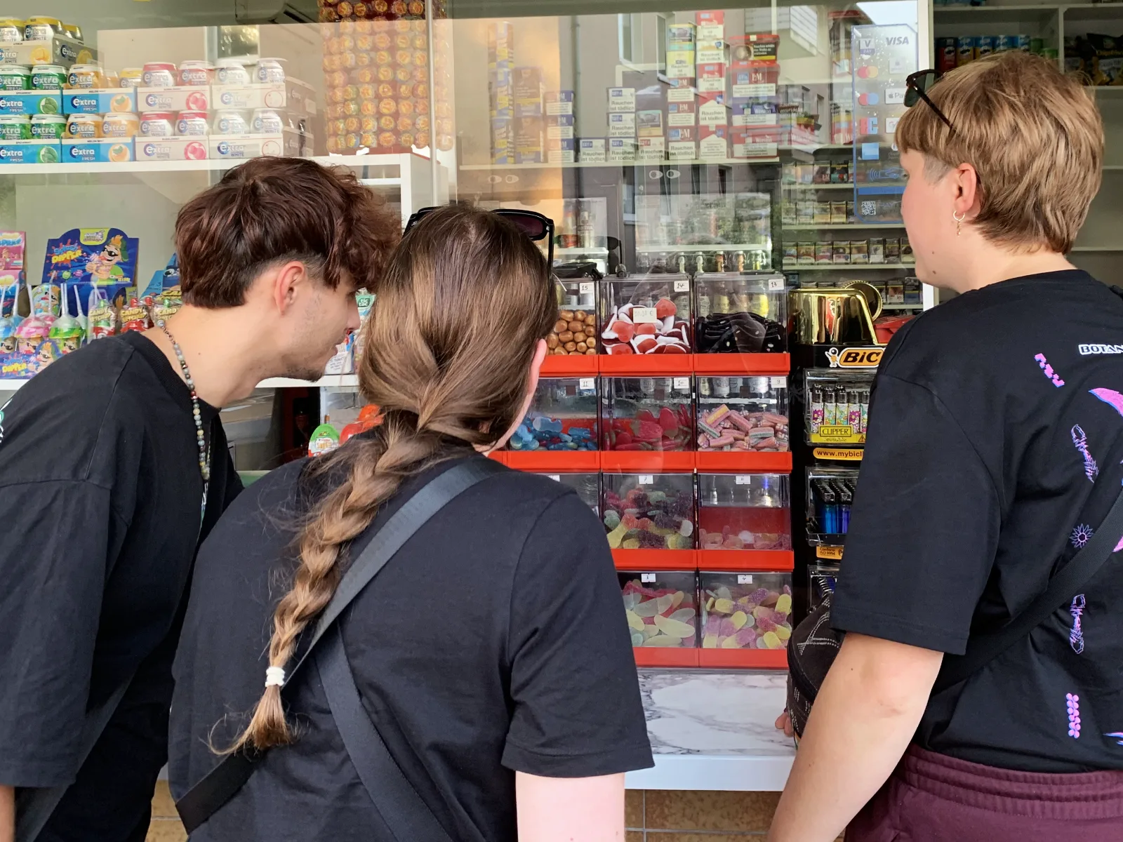 Rätsel-Büdchen-Tour in Bochum: Drei Mitspielende stehen vor der geöffneten Auslage eines Bochumer Büdchens.